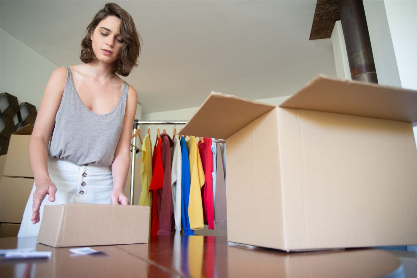 Una emprendedora prepara un pedido para enviarlo, junto a su ropa en venta